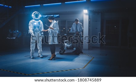 Diverse Team of Aerospace Scientists and Engineers Wearing White Coats Use Computers to Design New Space Suit Adapted for Galaxy Exploration and Travel. Constructing Astronaut Suit