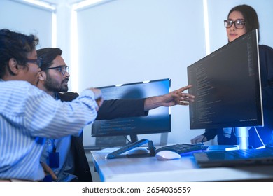 Diverse team of AI developers collaborating in a modern office. Indian male leading a discussion with Asian and Hispanic female colleagues on a machine learning project.