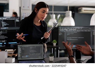 Diverse team of app developers using computer to write html code and develop algorithm program in software company office. Programmer working on user interface with html script and terminal window.