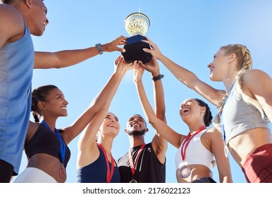 A diverse team athletes celebrating victory and golden trophy   looking excited  A fit   happy team professional athletes rejoicing after winning an award at an athletic sports event