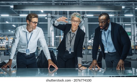 Diverse Team of Automotive Engineers Working in Office at Car Factory. Industrial Designers Talk and Make Gestures of Moving Invisible Object in Augmented Reality. Great Template for Your AR Objects - Powered by Shutterstock