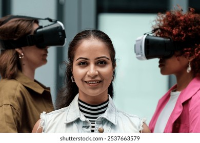 Diverse team of businesswomen is smiling while experiencing virtual reality using vr headsets, showcasing the future of technology in the workplace - Powered by Shutterstock