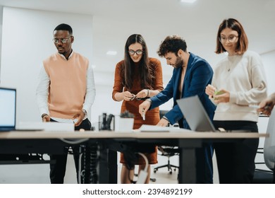 A diverse team collaborates in a bright office, analyzing reports and brainstorming strategies for business growth and project development. They work late night, embracing collaboration and teamwork. - Powered by Shutterstock