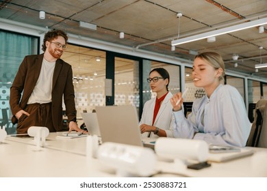 A diverse team collaborates in a modern office, sharing ideas and brainstorming to achieve goals and foster innovation - Powered by Shutterstock