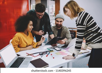 Diverse team of creative male and female designers in casual wear collaborating on development of project sitting at meeting table in office.Successful young people cooperating with each other - Shutterstock ID 1140396245