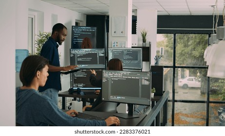 Diverse team of database developers analyzing code on terminal window, working with html script and artificial intelligence. System engineers talking about app developing interface.