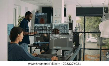 Diverse team of database developers analyzing code on terminal window, working with html script and artificial intelligence. System engineers talking about app developing interface.