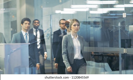 Diverse Team of Delegates/ Lawyers Led by Woman Confidently Marches Through the Corporate Building Hallway. Multicultural Crowd Of Resolute Business People in Stylish Marble and Glass Offices.