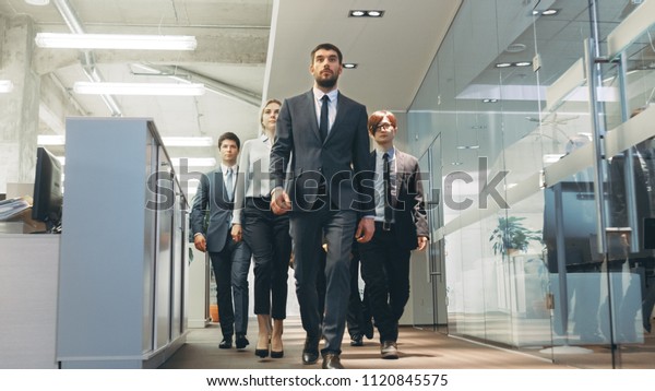 Diverse Team of Delegates/\
Lawyers Resolutely Marching Through the Corporate Building Hallway.\
Multicultural Crowd Of Businessmen and Businesswomen in\
Action.