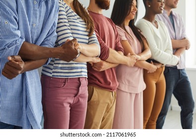 Diverse team of different happy young people standing together. Multiethnic group of good friends standing in a row, holding hands and smiling. Teamwork, unity and diversity concepts - Shutterstock ID 2117061965
