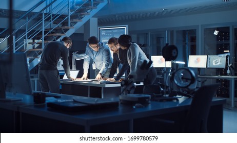 Diverse Team of Electronics Development Engineers Standing at the Desk Working with Documents, Solving Project Problems Late at Night. Specialists Working on Ultra Modern Industrial Design. - Powered by Shutterstock