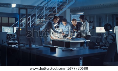 Diverse Team of Electronics Development Engineers Standing at the Desk with 3D Printer and PCB Motherboards. Specialists Working on Ultra Modern Industrial Design, Using Advanced Technology