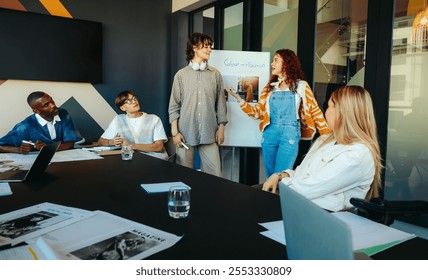 A diverse team engaged in a collaborative meeting in a modern office, discussing color theory and fashion concepts with passion and creativity. - Powered by Shutterstock