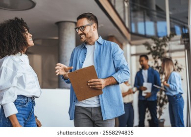 A diverse team engages in a lively discussion in a modern, open-plan office. This image depicts collaboration, teamwork, and professional interaction, reflecting a dynamic and productive workplace 
