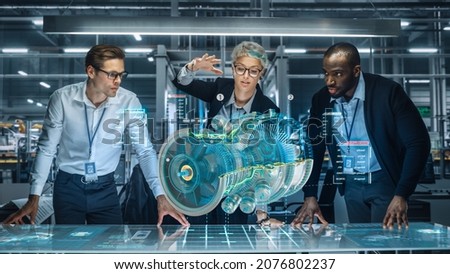 Diverse Team of Engineers Working in Office at Industrial Factory. Industrial Designers Discuss Jet Engine Augmented Reality Hologramm. Specialists Work in Technological Plane Development Facility. Stockfoto © 