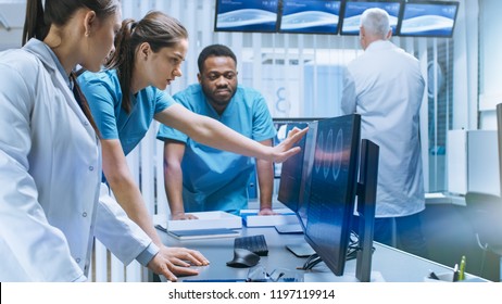 Diverse Team Of Medical Scientists Solve Problems And Point At Computer Screens Showing CT, MRI Scans. Neurologists / Neuroscientists Working In Brain Research Laboratory.