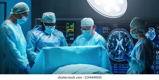 Diverse team of professional medical surgeons perform surgery in the operating room using high-tech equipment. Doctors work to save a patient in a modern hospital. Medicine, technology and - Powered by Shutterstock