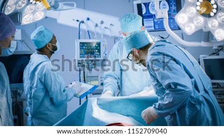 Diverse Team of Professional surgeon, Assistants and Nurses Performing Invasive Surgery on a Patient in the Hospital Operating Room. Real Modern Hospital with Authentic Equipment.