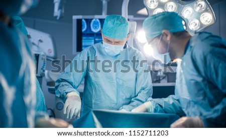 Diverse Team of Professional surgeon, Assistants and Nurses Performing Invasive Surgery on a Patient in the Hospital Operating Room. Surgeon Use Instruments. Modern Hospital with Authentic Equipment.