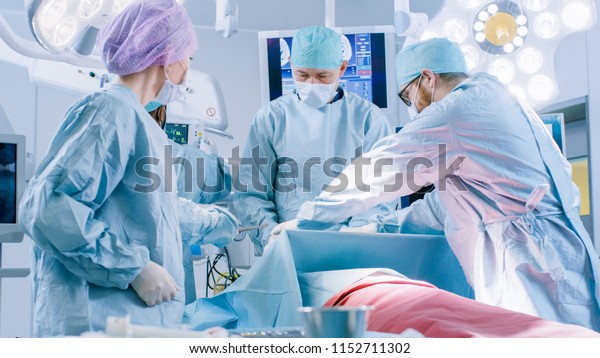 病院の手術室の患者に侵襲的な手術を行うプロの外科医の多様なチーム 手術やその他の器械 麻酔科医はバイタルを監視します の写真素材 今すぐ編集
