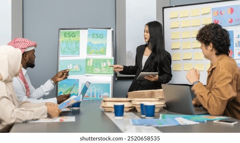 Diverse team professionals collaborating on sustainable development project during a corporate meeting, presentation eco-friendly designs with charts and data on renewable energy and green technology - Powered by Shutterstock