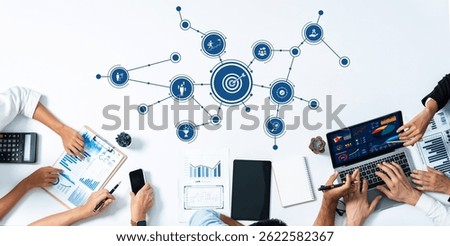 A diverse team of professionals is engaged in a collaborative meeting, analyzing data and discussing business strategies using digital tools and visual aids. Amity