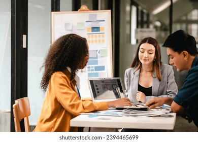 diverse team of professionals engaged in a website graphic design board meeting, sharing opinions on UX and UI design elements. Asian man, African American people, black, afro, caucasian female - Powered by Shutterstock