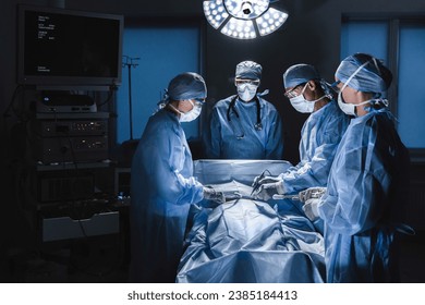 Diverse team of surgeons performing surgery on patient in hospital operating room. Urgent treatment, plastic surgery. Specialists saving patient`s life in operation theater. - Powered by Shutterstock