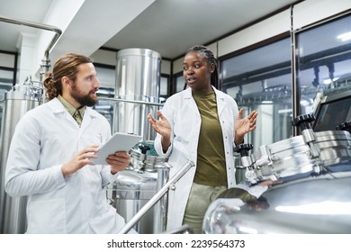 Diverse team of technologists checking equipment at brewery - Powered by Shutterstock