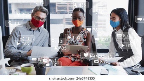 Diverse team working together, middle-aged Caucasian chef showing tablet. Asian and African American waitresses wearing masks, looking at screen - Powered by Shutterstock