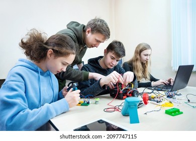 Diverse Teenager Pupils Build Robot Vehicle Learning At Table At STEM Engineering Science Education Class.