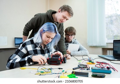 Diverse Teenager Pupils Build Robot Vehicle Learning At Table At STEM Engineering Science Education Class.