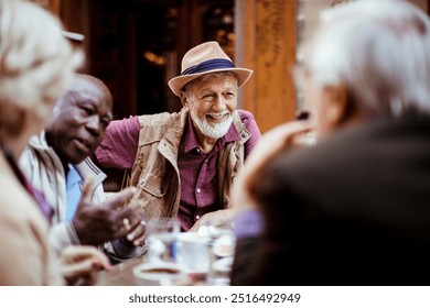 Diverse tourist senior friends sitting in outdoor cafe at city - Powered by Shutterstock