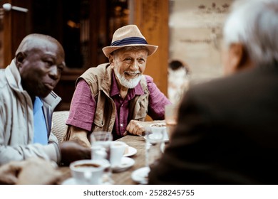 Diverse tourist senior friends sitting in outdoor cafe at city - Powered by Shutterstock