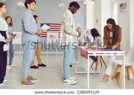 Diverse US voters at polling place. Multiracial multiethnic Caucasian and African American people standing in line waiting for their turn to come up to table of poll worker. USA elections concept