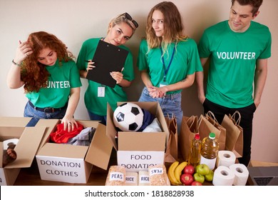 Diverse Volunteers Packing, Collecting Humanitarian Aid In Donation Box. Multi-ethnic Group Of People Working In Charitable Foundation Helping In Crises And Homeless