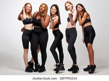 diverse women in black sportive wear blowing kiss on camera, have fun together, friendship between ladies of different nationalities and body size