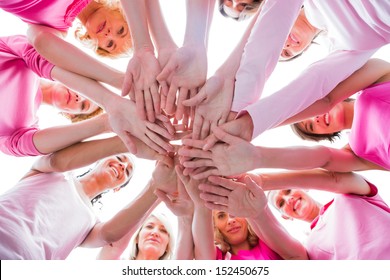 Diverse women smiling in circle wearing pink for breast cancer on white background - Powered by Shutterstock