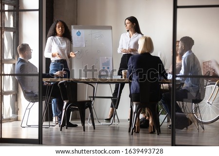 Diverse women startupper mixed-race and european ethnicity make perform presentation for investors during meeting at office boardroom, staff listening coaches attending at educational training concept