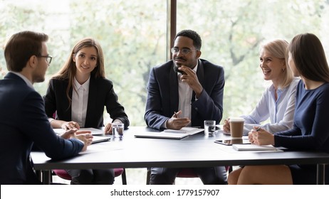 Diverse workmates participating in briefing listen project leader, ceo talking at group meeting in office boardroom. Corporate workshop, effective negotiations, friendly partners communication concept