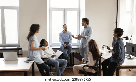 Diverse young business team employee speaking to group of colleagues, sharing ideas on office meeting, talking to group. Corporate teacher, mentor training multiethnic staff. Banner shot - Powered by Shutterstock