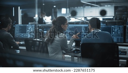 Diverse Young Colleagues Working on Computers in a Research Laboratory. Female Asking Advice from a Male Software Developer Colleague About a Solution for Their Collaborative Industrial Tech Project