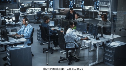 Diverse Young Indian Colleagues Working on Computers in a Research Laboratory. Focus on Female Software Developer Colleague Working on a Solution for Their Collaborative Industrial Tech Project - Powered by Shutterstock