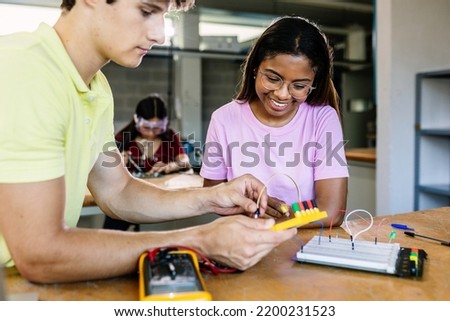 Diverse young school students learning electronic circuits at technology class - Education tech concept