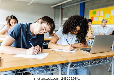 Diverse young students doing an exam at high school classroom. Education lifestyle and back to school concept. - Powered by Shutterstock