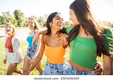 Diverse young women having fun walking outside - Happy girls talking and laughing together outdoors - Life style concept with joyful females enjoying summertime vibes 