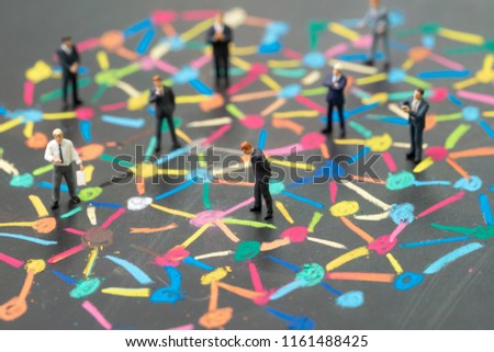 Diversify people or social network concept, miniature people businessmen standing on colorful pastel chalk line link and connect between multiple dot or peer on blackboard.