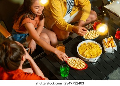 Diversity Asian millennial people friends enjoy dinner party with eating snack potato chip and soft drink at home outdoor rooftop for meeting reunion celebration holiday event new year with happiness  - Powered by Shutterstock