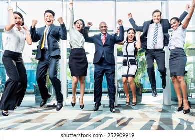 Diversity business team jumping celebrating success, Chinese, Indonesian, Indian, and Caucasian ethnicities