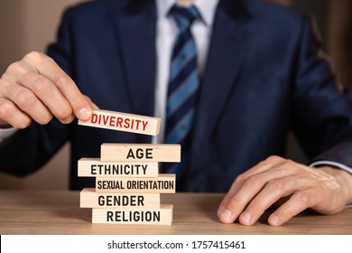 Diversity Concept. Business Man Building Stack From Wooden Blocks With Text Diversity, Age, Ethnicity, Sexual Orientation, Gender, Religion.